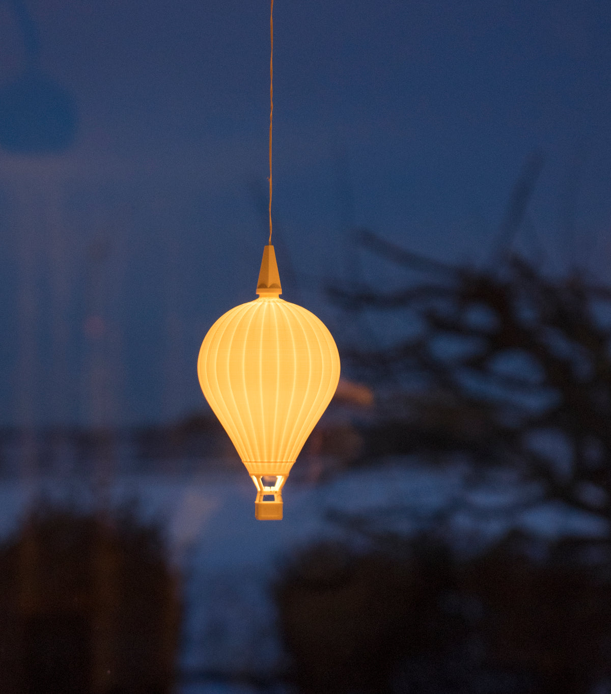 Leuchtender Heißluftballon-Lampenschirm von Benago Lights vor einem dunkelblauen Abendfenster
