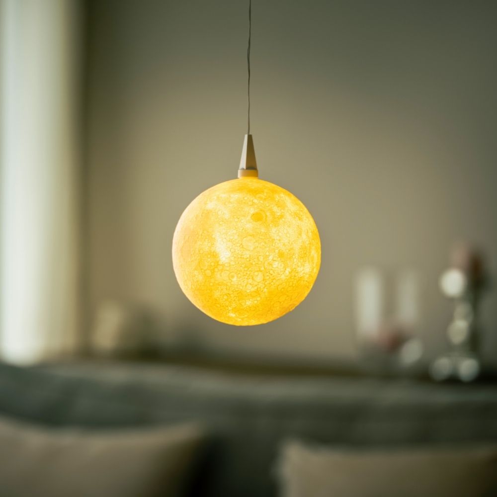 Warm leuchtender Lampenschirm The Moon von Benago Lights hängt an einem dünnen Kabel in einem Wohnraum